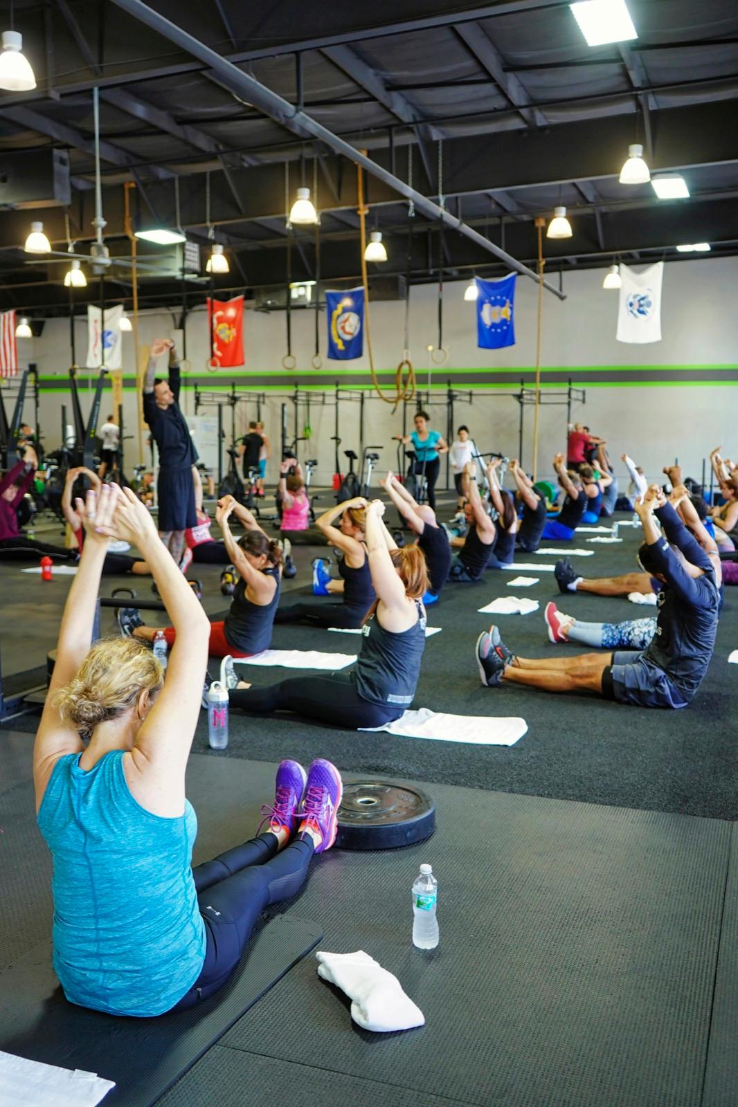 A group fitness class stretching together in a busy gym