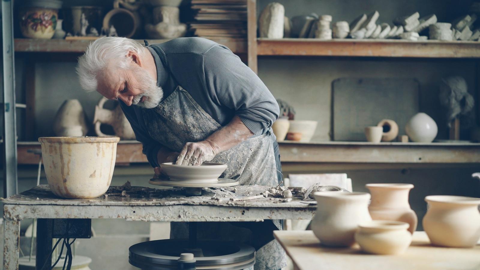 A potter shaping clay on the wheel in his workshop